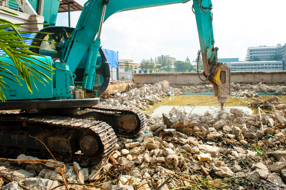 Backhoe Demolishing Old Swimming Pool